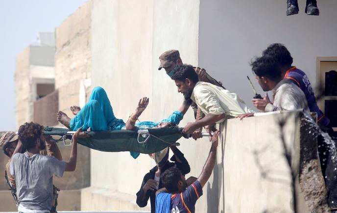 Evacuation d’un blessé sur les lieux du crash aérien, à Karachi, le 22 mai.