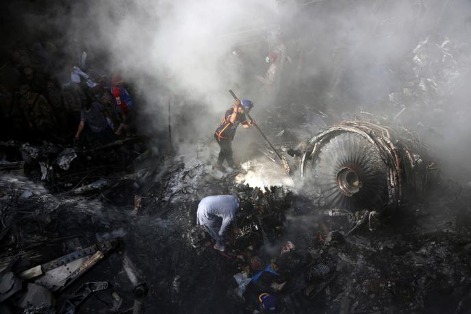 Des équipes de secours aidées par des riverains cherchent les corps des disparus dans les décombres, à Karachi, le 22 mai.