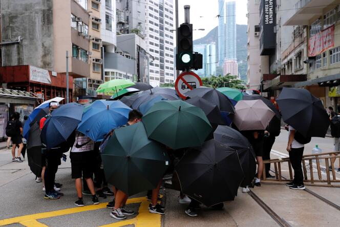 Les manifestants se protègent des gaz lacrymogènes au moyen de parapluies, à Hongkong, le 24 mai.