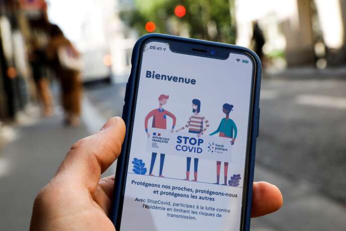Un homme tient un téléphone portable présentant l’application StopCovid, à Paris, le 27 mai.
