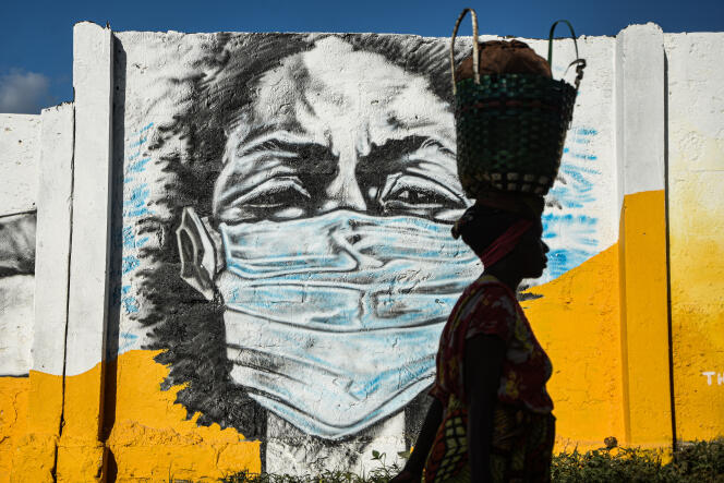 Une femme passe devant une peinture murale incitant au port du masque, à Dar es-Salaam, en Tanzanie, le 26 mai 2020.