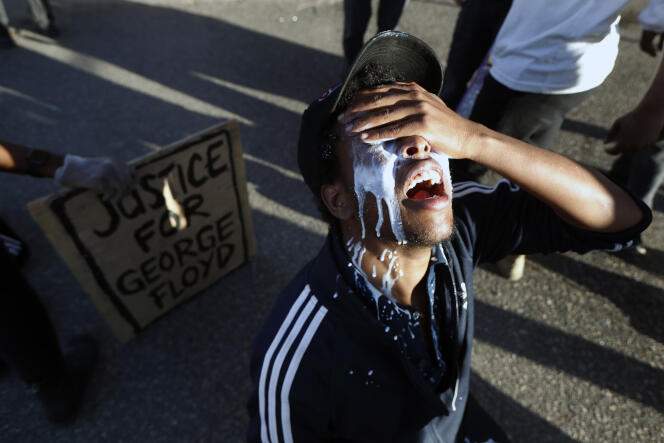 Un manifestant apaise les brûlures des gazs lacrymogènes avec du lait, le 29 mai dans les rues de Minneapolis, quatre jours après la mort de George Floyd.