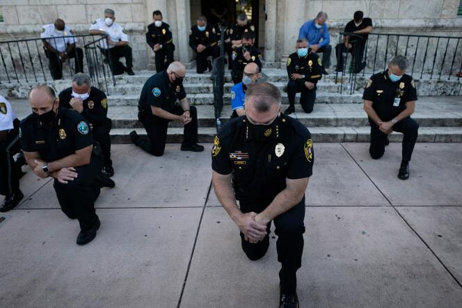 Des policiers adoptent le geste de protestation des manifestants, à Miami.