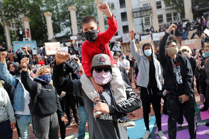 Venu de Vancouver (Washington), Bryan Anaya porte son fils Julian lors d’un rassemblement à la mémoire de George Floyd, à Portland (Oregon), le 31 mai 2020.