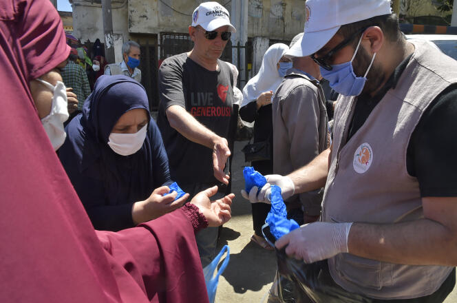 Distribution de masques dans une rue d’Alger, le 21 mai 2020.