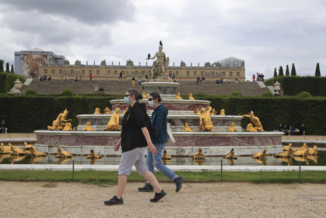 Des personnes portant des masques devant le bassin de Latone, dans les jardins du château de Versailles, dimanche 7 juin. Le château a rouvert ses portes la veille.