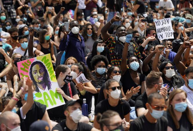 Des manifestants, le poing levé, dénoncent le racisme et les violences policières, à Madrid, le 7 juin.