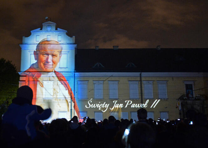 Une photo du pape Jean Paul II est projetée sur la façade du palais des évêques à Cracovie, lors de sa canonisation, en avril 2014.