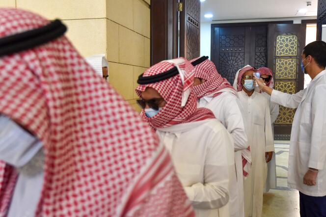 Un employé vérifie la température des fidèles à leur arrivée pour effectuer la prière de midi à la mosquée Al-Rajhi dans la capitale Riyad, le 31 mai.