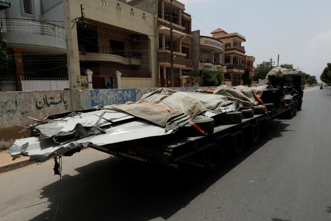 Un camion emporte les débris de l’Airbus qui s’est écrasé sur un quartier résidentiel de Karachi, le 22 mai.
