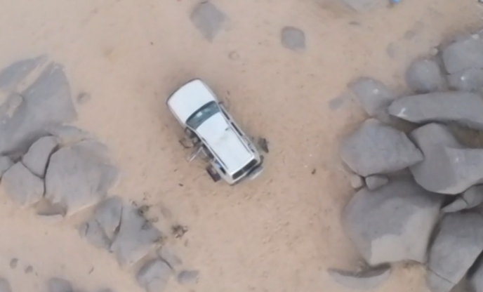 Photo de l’Etat major des armées, montrant le véhicule blanc garé à l’abri d’un amas rocheux, à côté duquel bivouaquait notamment l’émir d’AQMI.