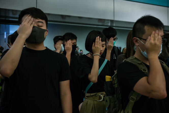 La main sur l’œil droit, des manifestants témoignent leur solidarité envers une infirmière blessée à l’œil dix jours plus tôt par un tir de la police à Hongkong, le 21 août 2019.