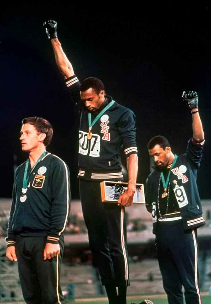 Tommie Smith (médaille d’or, au centre) et John Carlos (médaille de bronze), le poing ganté levé sur le podium du 200 m des Jeux olympiques, à Mexico, le 16 octobre 1968.