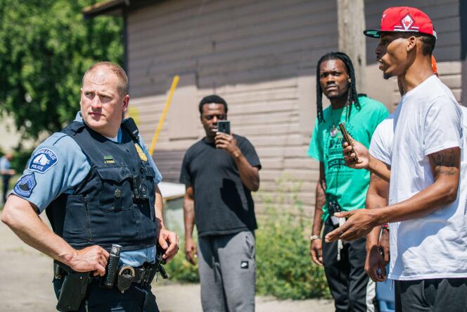 Un habitants échange avec un agent de police sur une scène de crime, à Minneapolis (Minnesota), le 16 juin.