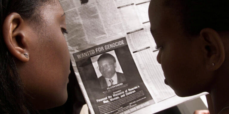 Readers look at a newspaper June 12, 2002 in Nairobi carrying the photograph of Rwandan Felicien Kabuga wanted by the United States. The United States published a 