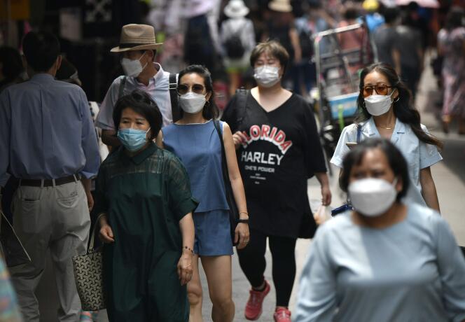 Des piétons portant des masques faciaux traversent un marché du centre de Séoul, en Corée du Sud, le 23 juin 2020.