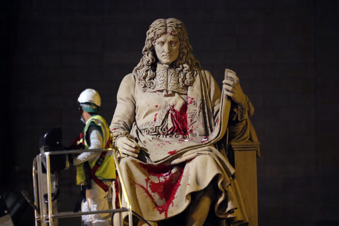Un agent de la Mairie de Paris nettoie la statue de Jean-Baptiste Colbert.