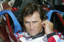 FILE PHOTO: Italian driver Alex Zanardi uses his ear sticks before sitting in the cockpit of his specially modified car at the Eurospeedway Lausitzring circuit in the eastern German town of Klettwitz May 11, 2003, before the German 500 CART race. Zanardi returned to the race track in Germany where he lost both legs in a crash. REUTERS/Fabrizio Bensch/File Photo