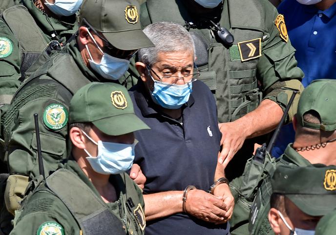 L’ancien premier ministre algérien Ahmed Ouyahia, qui purge une peine de quinze ans de prison pour corruption, est escorté par la police après avoir assisté aux funérailles de son frère, à Alger, le 22 juin 2020.