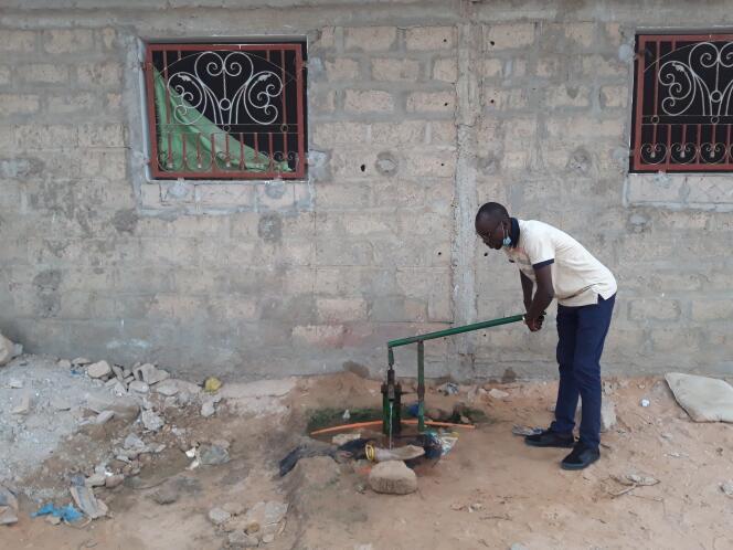 Quand l’eau ne coule même pas la nuit de son robinet, Papa Mbodj s’approvisionne auprès d’une pompe à eau traditionnelle, installée par ses voisins dans le quartier Comico Yeumbeul, dans la lointaine banlieue de Dakar, en juin 2020.