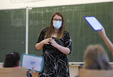 A teacher gives a lesson to the pupils at the Ziegelau elementary school in Strasbourg, eastern France, as primary and middle schools reopen in France on June 22, 2020. - After six weeks of unsteady school sessions and more than three months of class at home to fight against the spread of the new coronavirus Covid-19, French pupils and middle school students return to class on June 22, thanks to a lighter health protocol. (Photo by FREDERICK FLORIN / AFP)