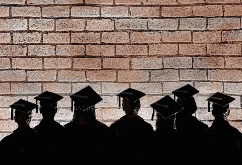 Row of graduate students staring at a brick wall