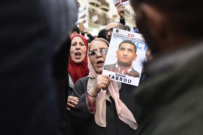 Une Algérienne brandit un portrait de Karim Tabbou lors d’une manifestation antigouvernementale à Alger, le 24 janvier 2020.