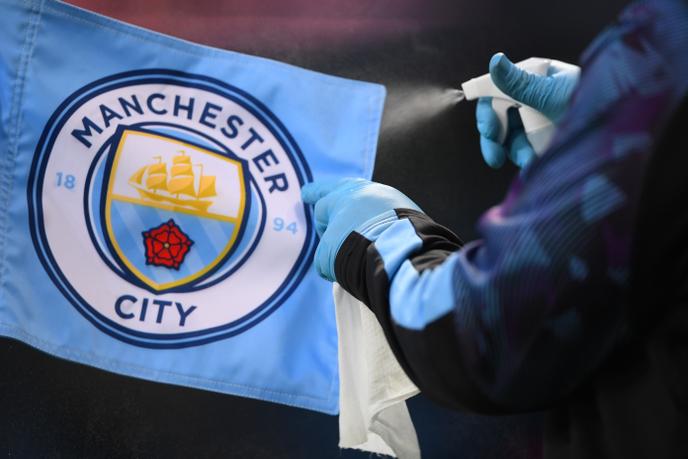Soccer Football - Premier League - Manchester City v Liverpool - Etihad Stadium, Manchester, Britain - July 2, 2020 A staff member disinfects the corner flag, as play resumes behind closed doors following the outbreak of the coronavirus disease (COVID-19) Laurence Griffiths/Pool via REUTERS EDITORIAL USE ONLY. No use with unauthorized audio, video, data, fixture lists, club/league logos or 