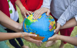 Close-up of friends holding a globe