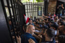 Anti-government protesters try to enter the main gate of the Lebanese interior ministry as they shout slogans against minister Mohammed Fahmi during a protest, in Beirut, Lebanon, Friday, July 3, 2020. (AP Photo/Hassan Ammar)