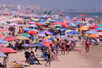 TOPSHOT - People enjoy a day at the Nord Beach in Gandia, near Valencia on July 1, 2020. The European Union reopened its borders to visitors from 15 countries but excluded the United States, where coronavirus deaths are spiking once again, six months after the first cluster was reported in China. / AFP / JOSE JORDAN

