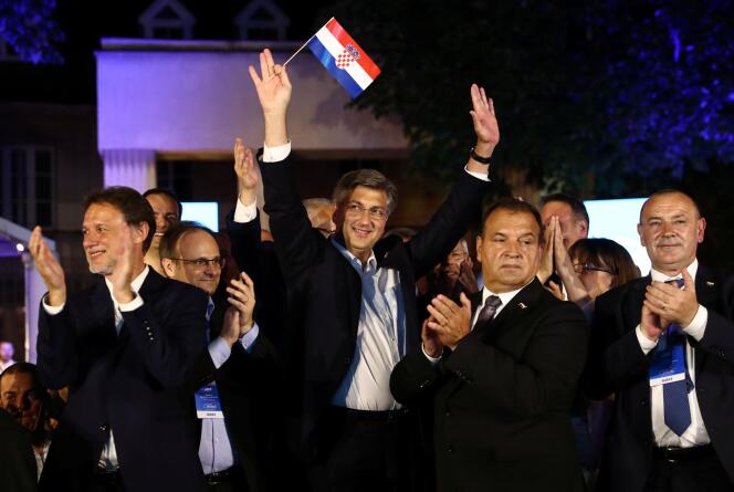 Le premier ministre conservateur sortant, Andrej Plenkovic, agite un drapeau croate après l’annonce des résultats des élections, à Zagreb, en Croatie, le 5 juillet.