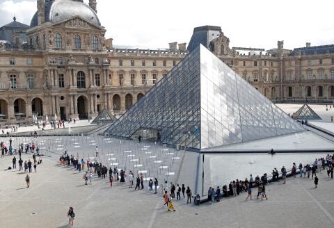 Visitors queue to enter the Louvre Pyramid designed by Chinese-born U.S. architect Ieoh Ming Pei in Paris as the museum reopens its doors to the public after almost 4-month closure due to the coronavirus disease (COVID-19) outbreak in France, July 6, 2020. REUTERS/Charles Platiau