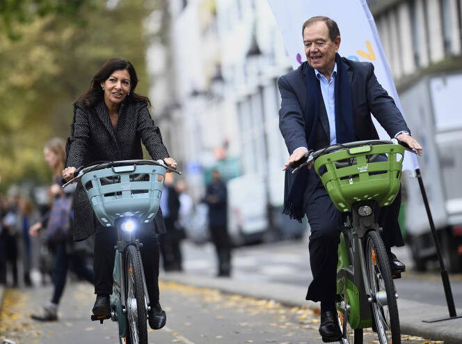 Anne Hidalgo et Patrick Ollier sur les nouveaux vélos Vélib’ Métropole, près du bassin de La Villette à Paris, en octobre 2017.