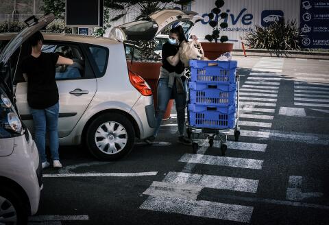A person picks up their groceries at a supermarket drive-through, on 6 May 2020 in Givors near Lyon, southeastern France, on the 51st day of a strict lockdown in France to stop the spread of COVID-19, caused by the novel coronavirus. (Photo by JEAN-PHILIPPE KSIAZEK / AFP)