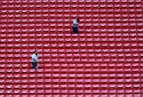 Workers clean the stands before the start of the Mexican football tournament match between Guadalajara and Tigres in Guadalajara, Jalisco state, Mexico, on July 8, 2020, in the middle of the new coronavirus pandemic. The match was held behind closed doors and respecting sanitary measures to prevent the spread of COVID-19 coronavirus. / AFP / Ulises Ruiz 