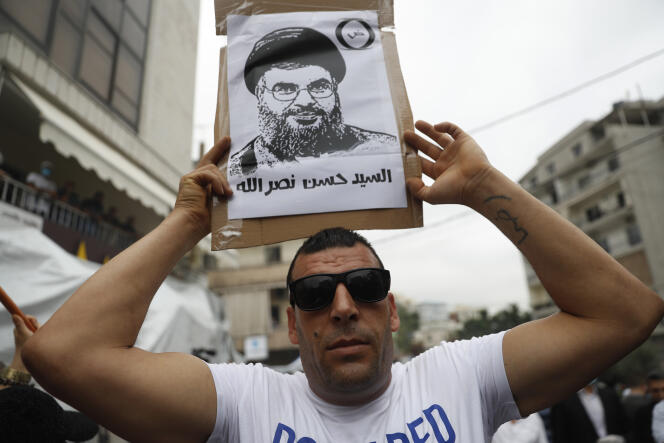Un partisan du Hezbollah tient une pancarte représentant son chef Hassan Nasrallah lors d’une manifestation à Aukar (Liban), le 10 juillet.