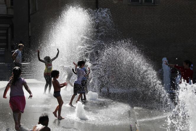Des enfants jouent dans une fontaine publique, sur la place Charles-de-Gaulle, à Toulouse, le 8 juillet.
