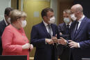 German Chancellor Angela Merkel, left, speaks with French President Emmanuel Macron, center, and European Council President Charles Michel, right, during a round table meeting at an EU summit in Brussels, Friday, July 17, 2020. Leaders from 27 European Union nations meet face-to-face on Friday for the first time since February, despite the dangers of the coronavirus pandemic, to assess an overall budget and recovery package spread over seven years estimated at some 1.75 trillion to 1.85 trillion euros. (Stephanie Lecocq, Pool Photo via AP)