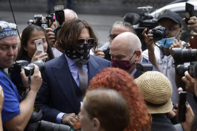 Actor Johnny Depp is surrounded by fans and the media as he arrives at the High Court in London, Friday, July 17, 2020. Depp is suing News Group Newspapers, publisher of The Sun, and the paper's executive editor, Dan Wootton, over an April 2018 article that called him a "wife-beater." The Sun's defense relies on a total of 14 allegations by his ex-wife Amber Heard of Depp's violence. He strongly denies all of them. (AP Photo/Kirsty Wigglesworth)