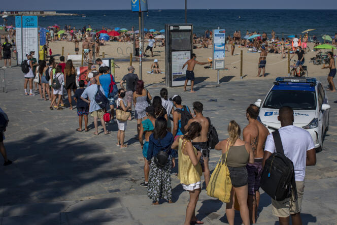 Des personnes font la queue pour accéder aux plages de Barcelone, samedi 18 juillet, la police bloquant l’accès en raison d’un nombre trop important de baigneurs ignorant les appels des autorités à rester confinés.
