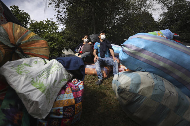 Un couple de migrants vénézuéliens attend un bus pour rentrer au pays, le 2 juillet à Bogota, Colombie.