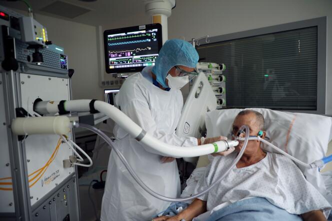 Christian George, directeur adjoint de l’Institut de recherches sur la catalyse et l’environnement de Lyon (Ircelyon), aide un patient atteint du Covid-19 à utiliser un appareil d’analyse de l’air expiré, le 22 juillet 2020.