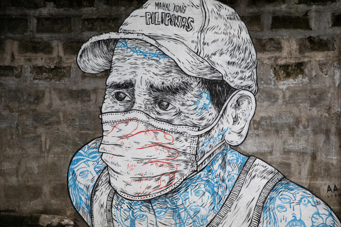 Peinture murale d’un homme portant un masque, sur un trottoir de Quezon City, aux Philippines, le 30 juillet.