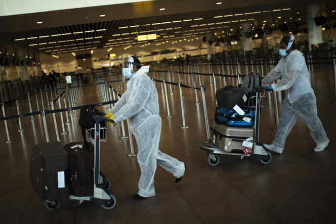 Des passagers, totalement protégés, à l’aéroport de Bruxelles, le 29 juillet.