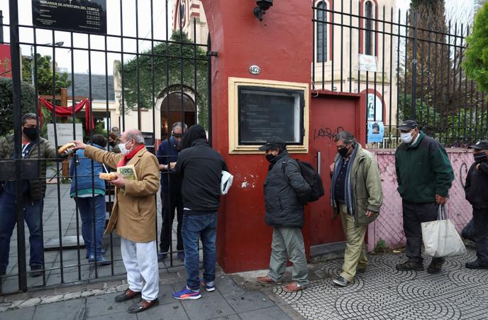 Des gens font la queue pour recevoir une ration de ragoût dans une soupe populaire organisée à l’église de Caacupe, à Buenos Aires, en Argentine, le 23 juillet.