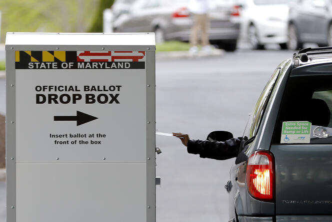 Un automobiliste poste un bulletin de vote lors de l’élection spéciale du 7e district du Congrès, à Windsor Mill, dans le Maryland, le 28 avril 2020.