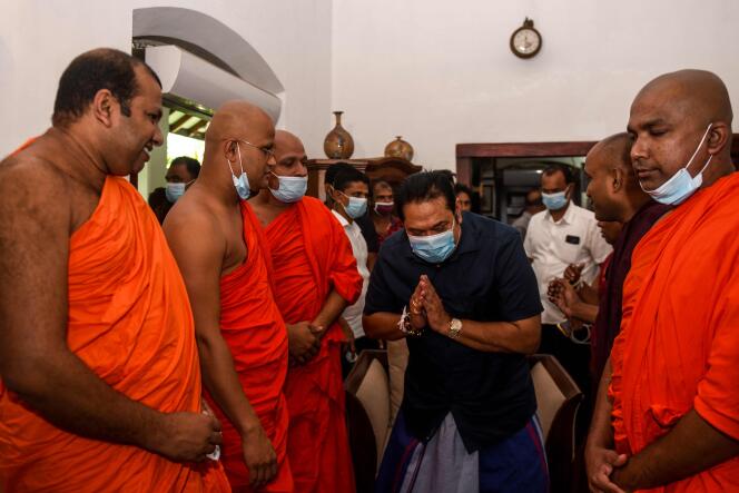 Le premier ministre du Sri Lanka, Mahinda Rajapaksa, salue des moines bouddhistes dans la ville de Tangalle le 7 août.