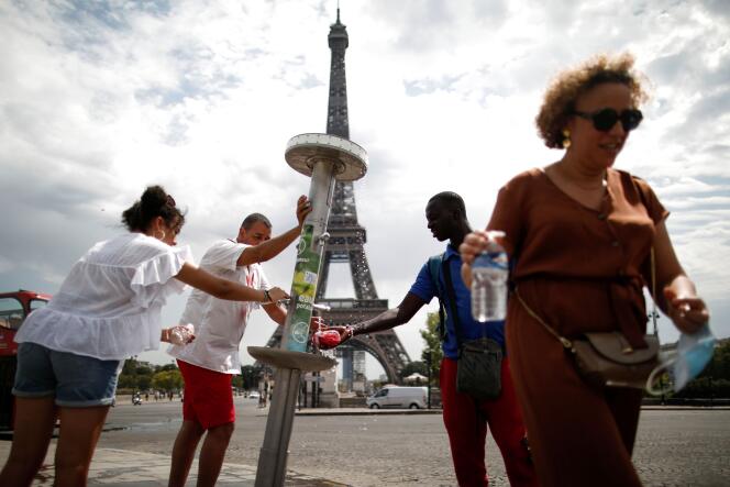 Des personnes se rafraîchissent à une fontaine à Paris, le 8 août.