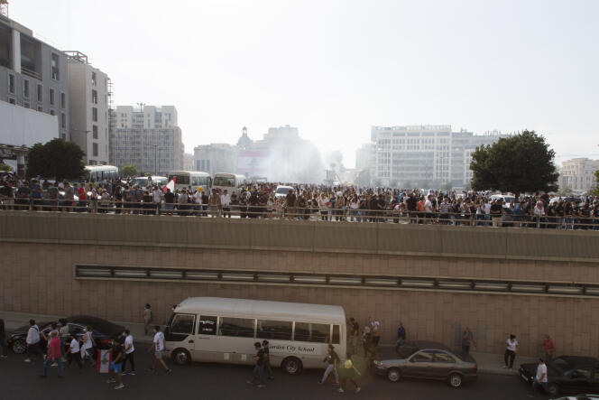 De la fumée est causée par des cartouches de gaz lacrymogènes,  alors que les manifestants arrivent au centre-ville de Beyrouth, au Liban, le 8 août, pour prendre part à la première manifestation suite à l’explosion au port de la capitale libanaise.